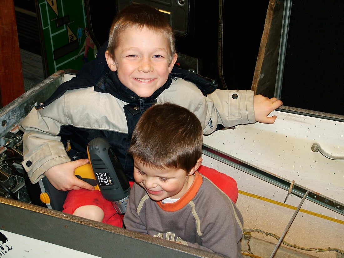 Deux enfants démontent un flipper vintage à la maison : la transmission du flipper de génération en génération