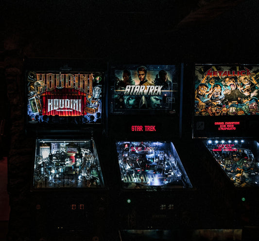 Row of pinball machines lined up on the floor of an expo — Pinball Expo 2026, Chicago