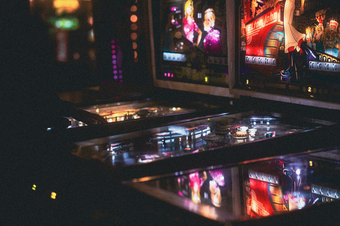 Flippers vintage illuminés dans une salle d'arcade sombre — la renaissance du rétro