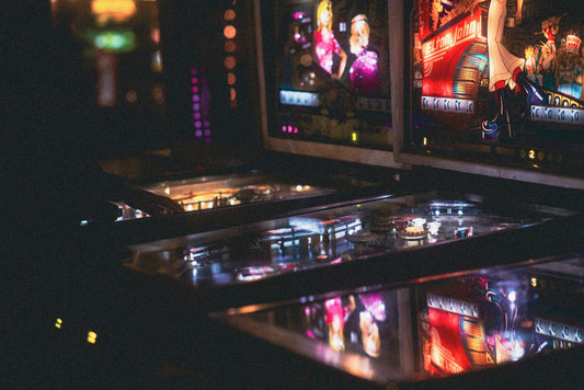 Flippers vintage illuminés dans une salle d'arcade sombre — la renaissance du rétro